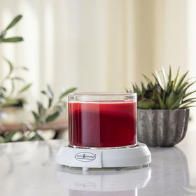 Candle warmer plate with a red jar candle, representative of plate-style electric candle warmers