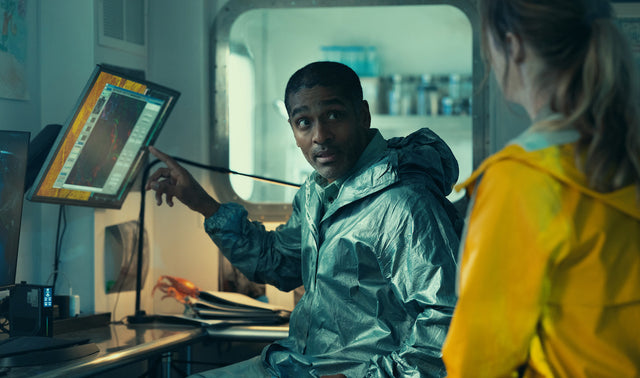 A marine researcher studies ocean data inside the research station in Netflix's Below