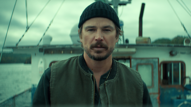 Josh Hartnett in a dark knit cap and green work vest aboard a fishing boat as Calvin Penney in Netflix's Below
