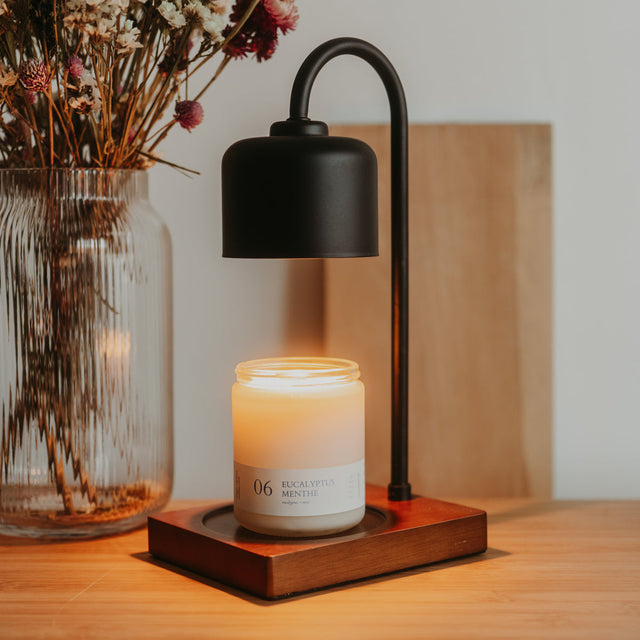 Matte black and wood candle warmer lamp in a minimalist setting. Illustrative reference for this article; exact model match not independently verified.