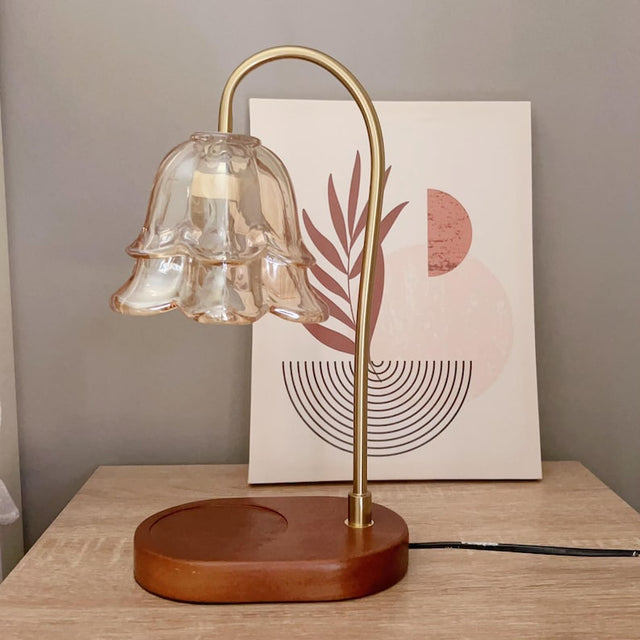 Floral glass wax melt warmer lamp with a curved brass arm and walnut base