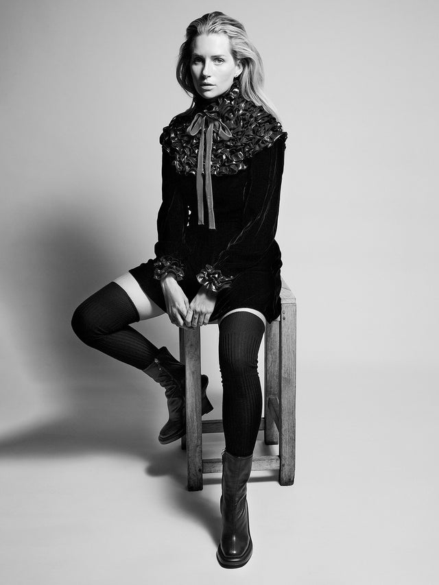 Lottie Moss seated in a black velvet fashion look during a studio portrait
